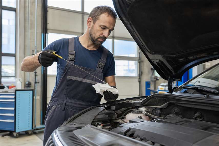 Mecânico revisando motor de veículo em oficina